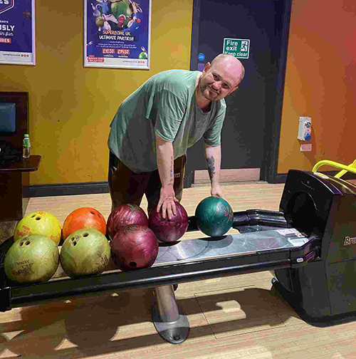 A resident taking part in the bowling trip smiling at the camera